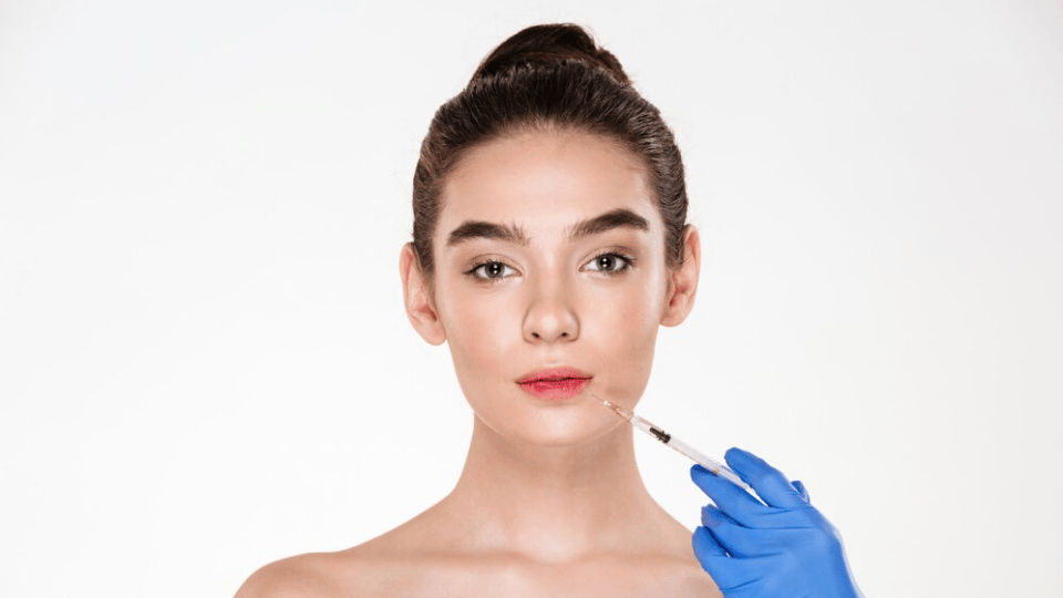 Woman receiving a Profhilo treatment with a syringe held by a gloved hand.